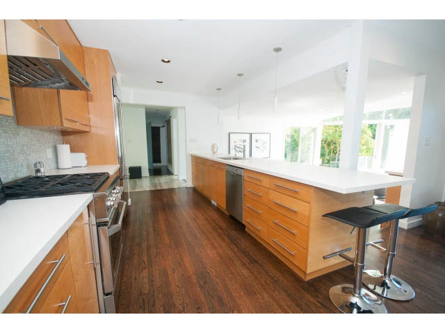 Bright kitchen with white countertops, hardwood floors, and a view of the garden. - 6190 Candia Place, West Vancouver