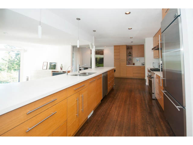Bright kitchen with light wood cabinets, white countertops, and hardwood floors. - 6190 Candia Place, West Vancouver