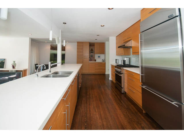 Bright kitchen with white countertops, hardwood floors, and stainless steel appliances. - 6190 Candia Place, West Vancouver