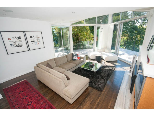 Spacious living room with hardwood floors, large windows, and modern furnishings. - 6190 Candia Place, West Vancouver