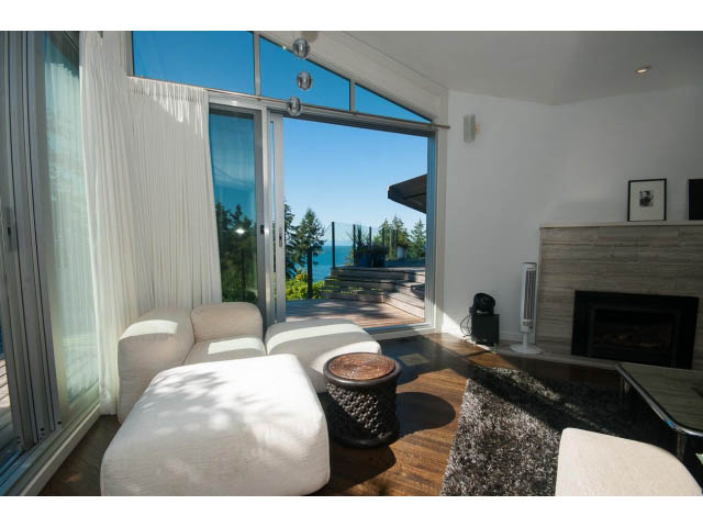 Living room with large windows, hardwood floors, and a city view. - 6190 Candia Place, West Vancouver