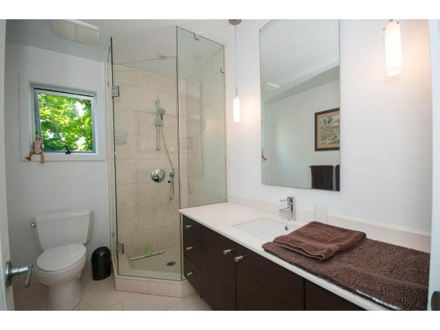 Bright bathroom with modern shower, dark wood cabinets, and a city view. - 6190 Candia Place, West Vancouver