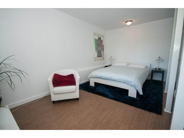 Bright living room with white furniture, dark rug, and artwork on wall. - 6190 Candia Place, West Vancouver