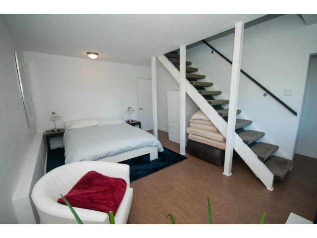 Furnished den with white walls, wooden floors, and a modern staircase leading to the upper level. - 6190 Candia Place, West Vancouver