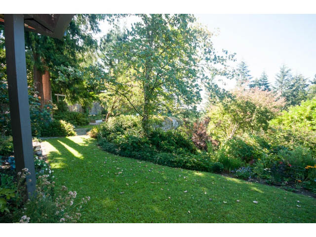 Bright garden with lush greenery and blooming flowers, perfect for relaxation. - 6190 Candia Place, West Vancouver