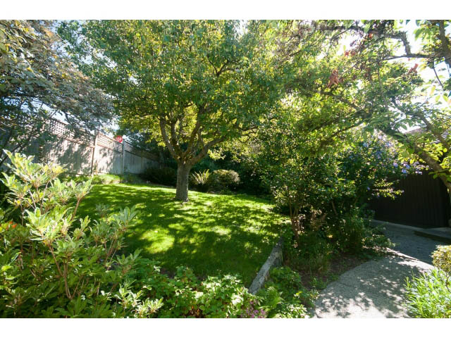 Furnished garden with lush greenery and a stone pathway. - 6190 Candia Place, West Vancouver