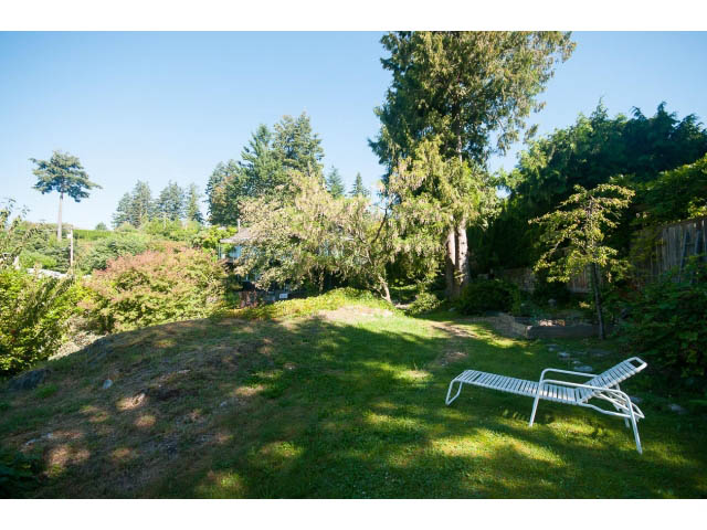 Furnished patio with lounge chair and lush greenery, perfect for relaxation. - 6190 Candia Place, West Vancouver
