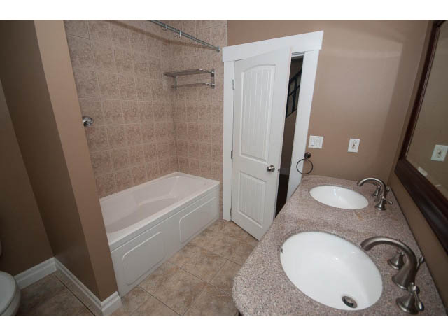Bathroom with granite countertop, modern fixtures, and tiled walls. - 2939 West 30th Ave, Vancouver West Side