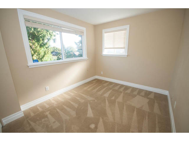 Bright bedroom with carpeted floor and large windows, allowing natural light. - 2939 West 30th Ave, Vancouver West Side