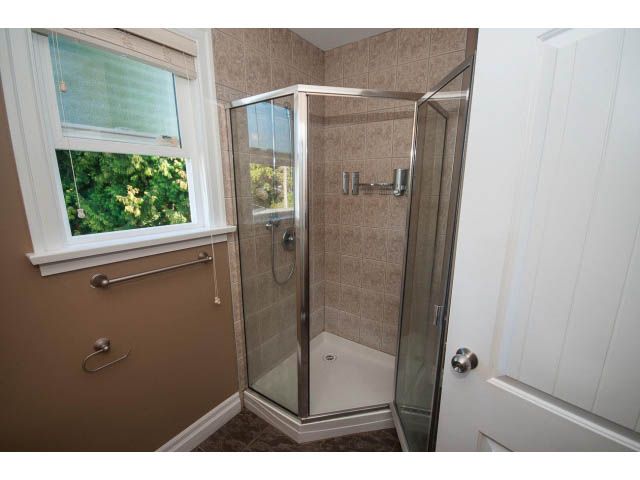 Bright bathroom with corner shower and window view. - 2939 West 30th Ave, Vancouver West Side