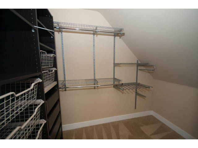 Attic storage area with metal shelving and carpeted floor. - 2939 West 30th Ave, Vancouver West Side