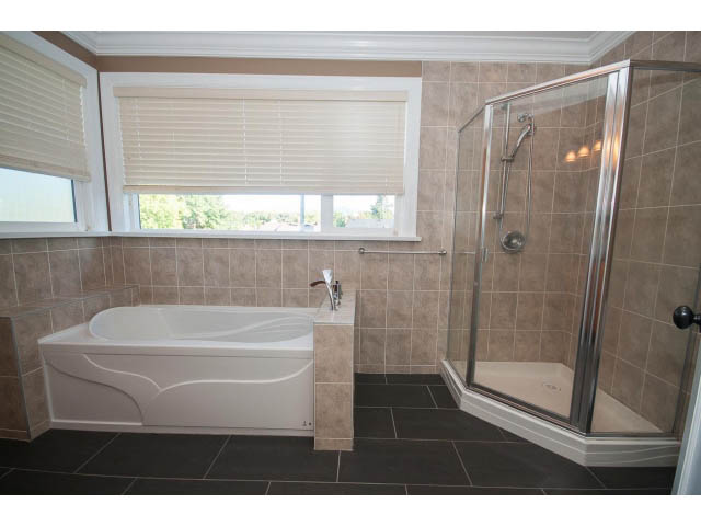 Spacious bathroom with large bathtub, walk-in shower, and window view. - 2939 West 30th Ave, Vancouver West Side