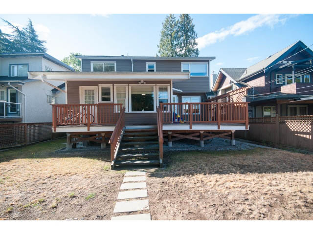 Bright living room with wooden deck and stairs leading to upper level, surrounded by other houses. - 2939 West 30th Ave, Vancouver West Side