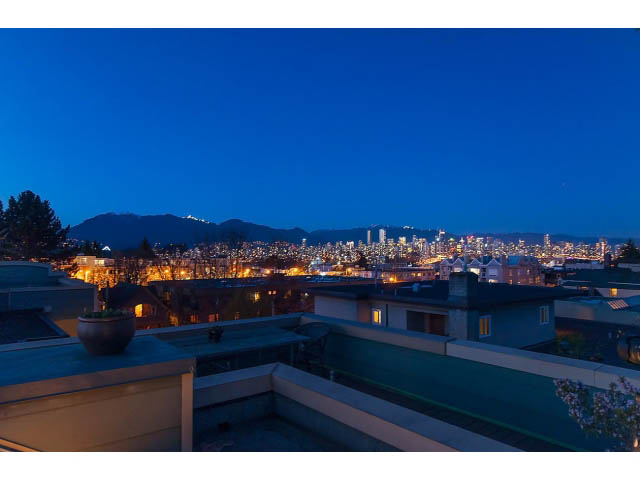 Spacious 2-bedroom condo with stunning city view at dusk, featuring rooftop access and modern furnishings.