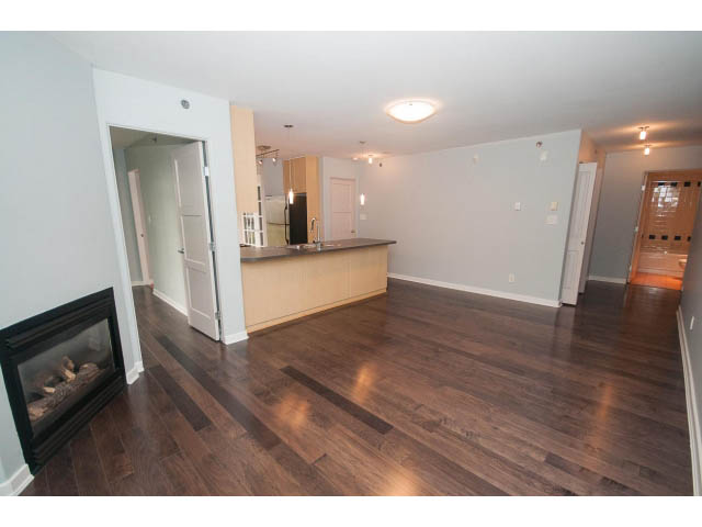 Open-concept living area with hardwood floors and modern kitchen counter. - 602 - 819 Hamilton Street, Vancouver Downtown