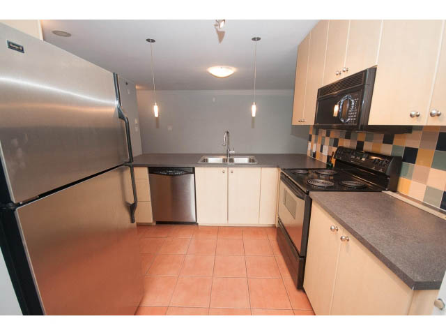Bright kitchen with stainless steel appliances, granite countertops, and checkered backsplash. - 602 - 819 Hamilton Street, Vancouver Downtown