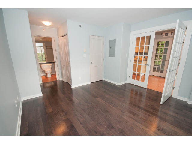 Bright living room with hardwood floors and French doors leading to a balcony. - 602 - 819 Hamilton Street, Vancouver Downtown