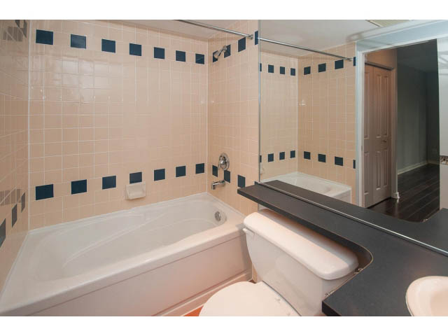 Furnished bathroom with black and white tiled walls, modern sink, and bathtub. - 602 - 819 Hamilton Street, Vancouver Downtown
