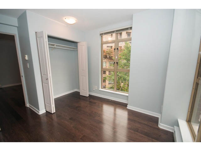 Spacious living room with hardwood floors, large windows, and built-in closet. - 602 - 819 Hamilton Street, Vancouver Downtown