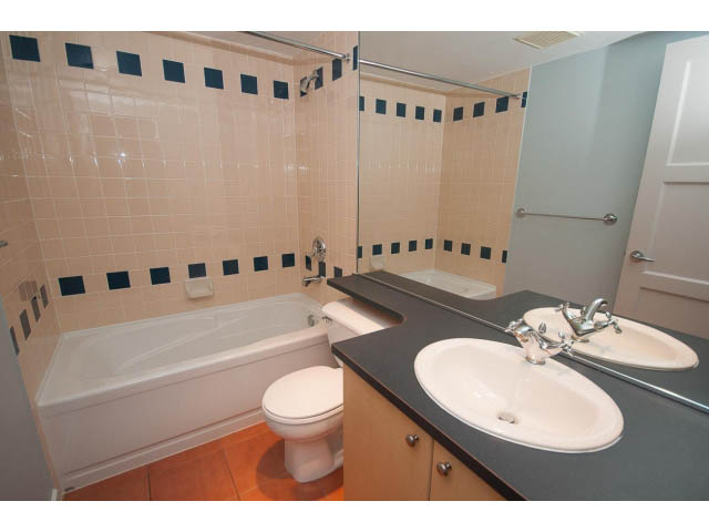 Bright bathroom with white sink, countertop, and bathtub, hardwood floors. - 602 - 819 Hamilton Street, Vancouver Downtown