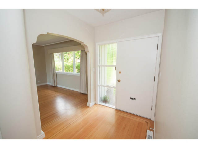 Bright living room with hardwood floors and arched entryway leading to another room. - 221 Carisbrooke Crescent, North Vancouver