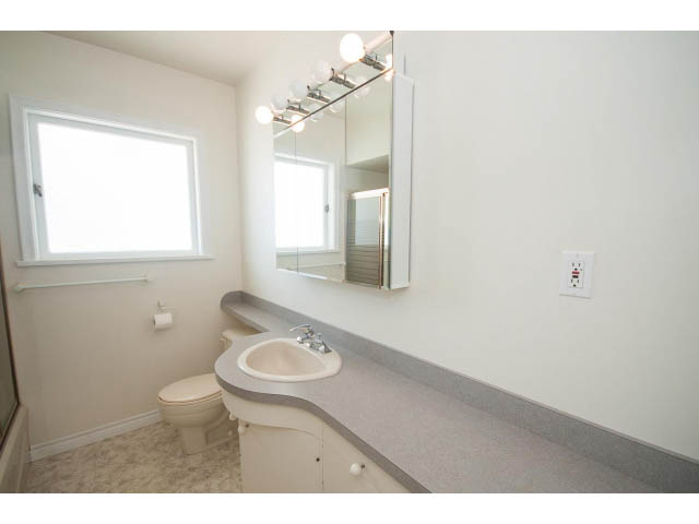 Bright bathroom with white walls, modern sink, and large mirror. - 221 Carisbrooke Crescent, North Vancouver