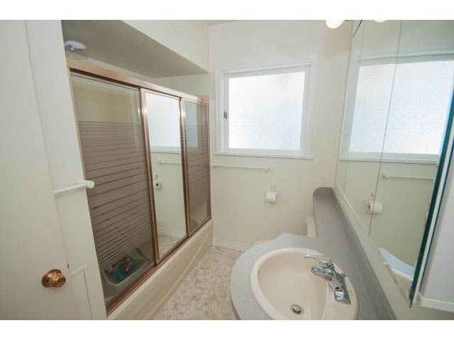 Bright bathroom with a large vanity mirror and a sliding glass shower. - 221 Carisbrooke Crescent, North Vancouver