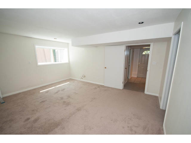 Bright living room with carpeted floors and a sliding glass door leading to another room. - 221 Carisbrooke Crescent, North Vancouver
