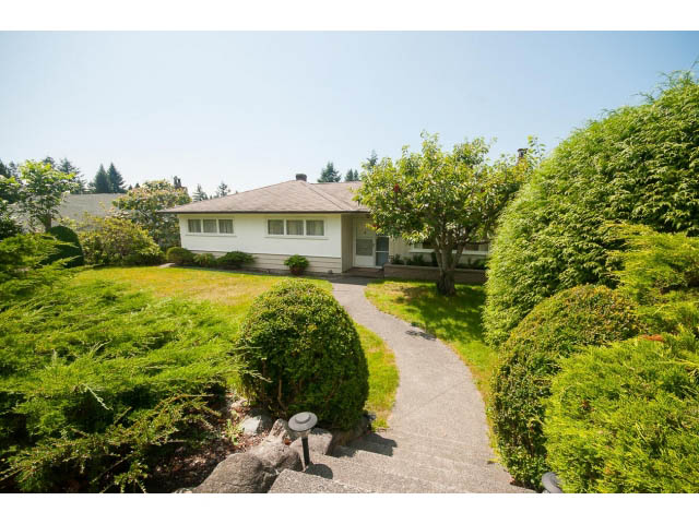 Furnished 4-bedroom house with lush green garden and stone pathway leading to the entrance. - 221 Carisbrooke Crescent, North Vancouver