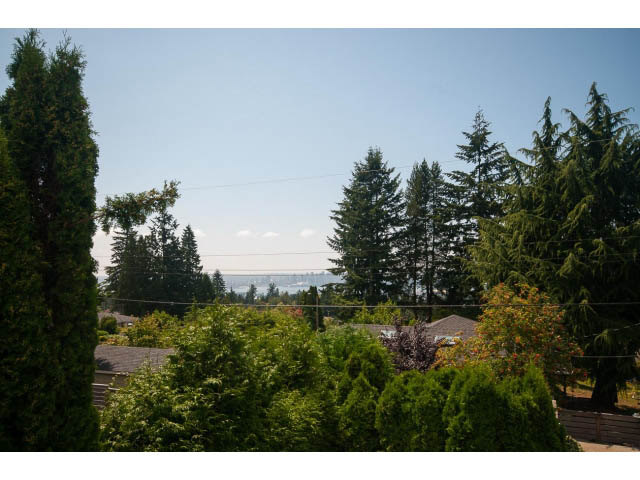 Bright living room with city view and lush greenery. - 221 Carisbrooke Crescent, North Vancouver