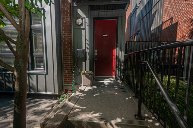 Furnished townhouse entrance with red door and metal railing. - 2753 Guelph Street, Vancouver East Side