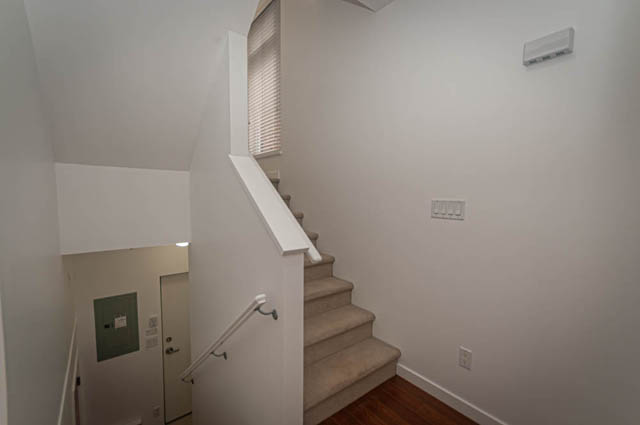Staircase leading to upper level with white walls and hardwood floors. - 2753 Guelph Street, Vancouver East Side