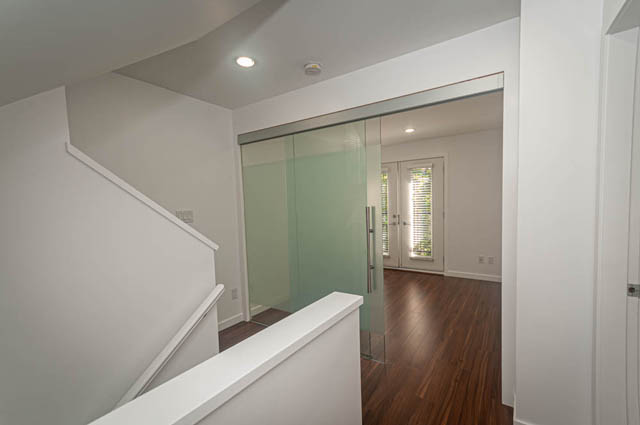 Bright entryway with frosted glass sliding doors and hardwood floors. - 2753 Guelph Street, Vancouver East Side