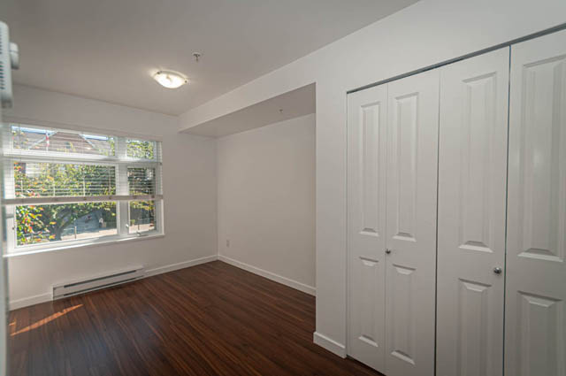 Bright kitchen with white cabinetry and hardwood floors, natural light from windows. - 2753 Guelph Street, Vancouver East Side
