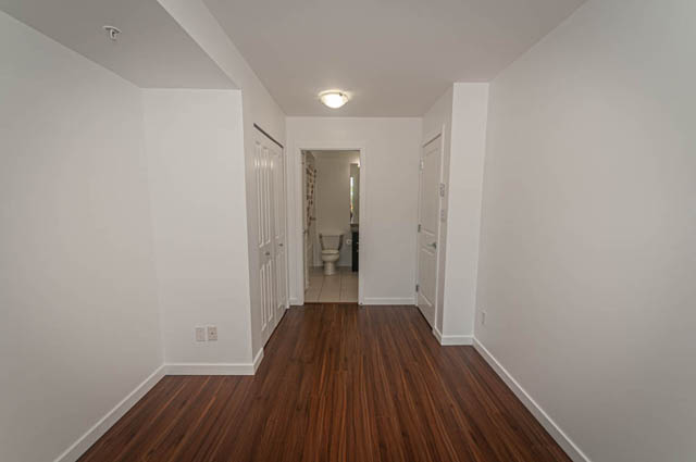 Bright hallway with hardwood floors and white walls leading to a den area. - 2753 Guelph Street, Vancouver East Side
