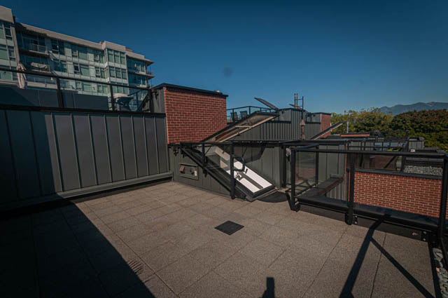 Furnished rooftop deck with brick accents and city view. - 2753 Guelph Street, Vancouver East Side