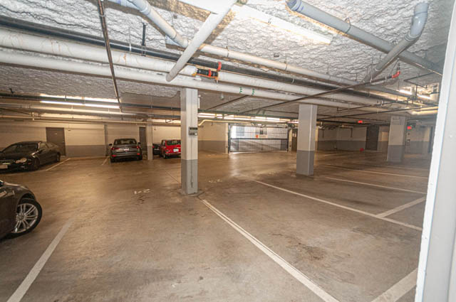 Spacious open-concept living area with exposed ductwork and ample parking. - 2753 Guelph Street, Vancouver East Side
