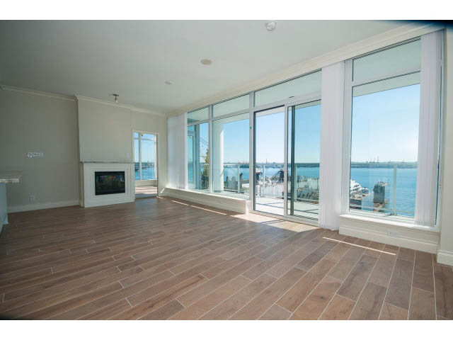 Bright living room with hardwood floors and a stunning city view. - 1001 - 199 Victory Ship Way, North Vancouver