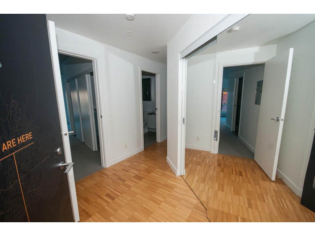 Bright living room with hardwood floors and sliding glass doors leading to another room. - 803 - 128 Cordova St W, Vancouver Downtown