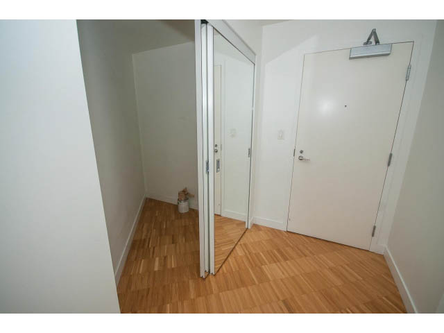 Bright living room with hardwood floors and sliding glass door leading to another room. - 803 - 128 Cordova St W, Vancouver Downtown