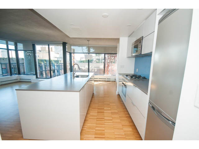 Bright kitchen with white cabinets, hardwood floors, and a city view. - 803 - 128 Cordova St W, Vancouver Downtown