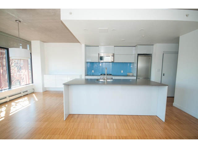 Bright kitchen with white cabinets, blue backsplash, and hardwood floors. - 803 - 128 Cordova St W, Vancouver Downtown