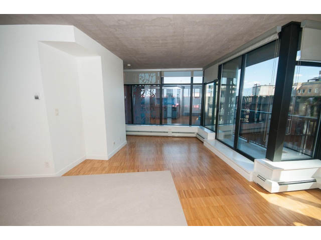 Spacious living room with hardwood floors and large windows offering city views. - 803 - 128 Cordova St W, Vancouver Downtown