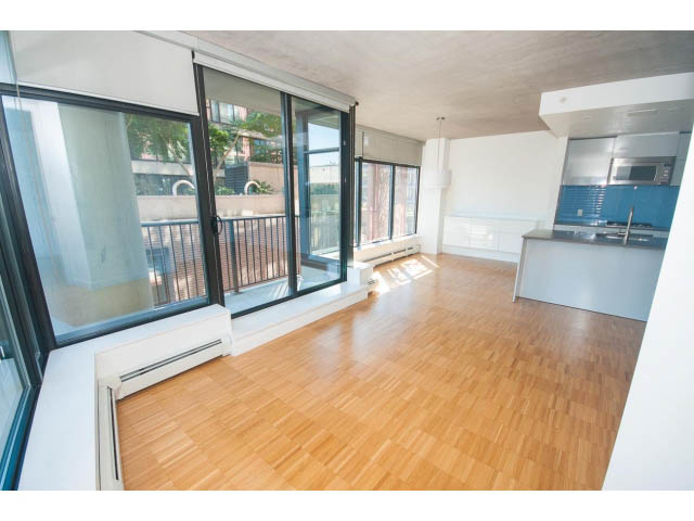 Bright living room with hardwood floors, large windows, and city view. - 803 - 128 Cordova St W, Vancouver Downtown