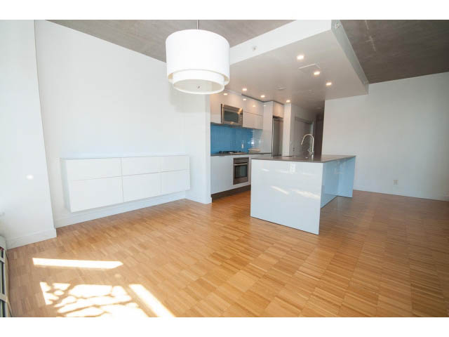 Bright kitchen with white cabinetry, hardwood floors, and a modern pendant light. - 803 - 128 Cordova St W, Vancouver Downtown