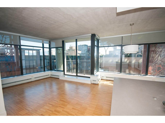 Spacious living room with hardwood floors, large windows, and city view. - 803 - 128 Cordova St W, Vancouver Downtown