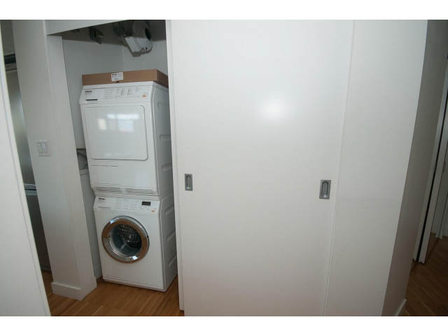Laundry room with stacked washer and dryer, hardwood floors. - 803 - 128 Cordova St W, Vancouver Downtown