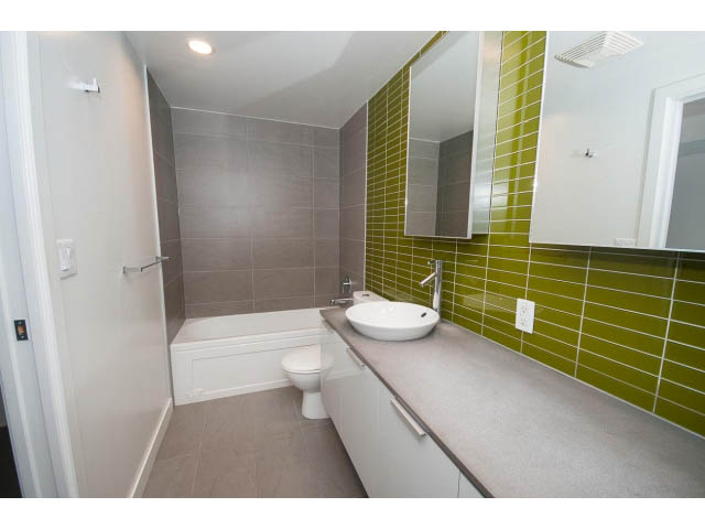 Bright bathroom with green tiles and modern fixtures. - 803 - 128 Cordova St W, Vancouver Downtown