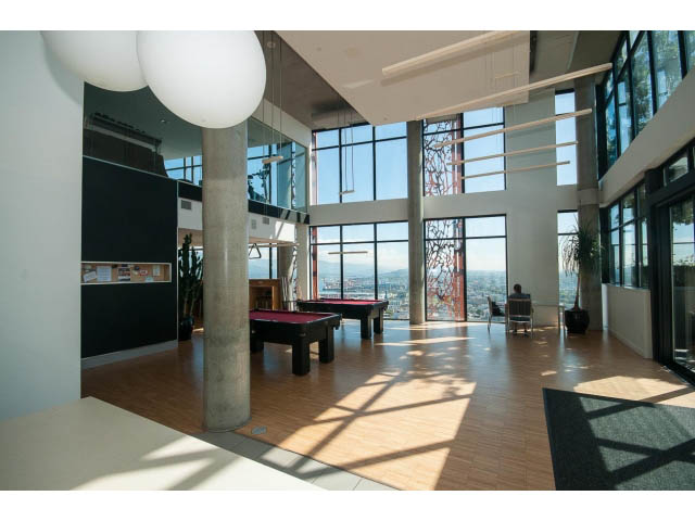 Furnished living room with large windows, hardwood floors, and city view. - 803 - 128 Cordova St W, Vancouver Downtown