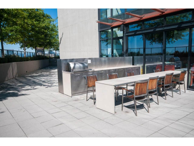 Furnished patio with modern seating and glass wall view. - 803 - 128 Cordova St W, Vancouver Downtown